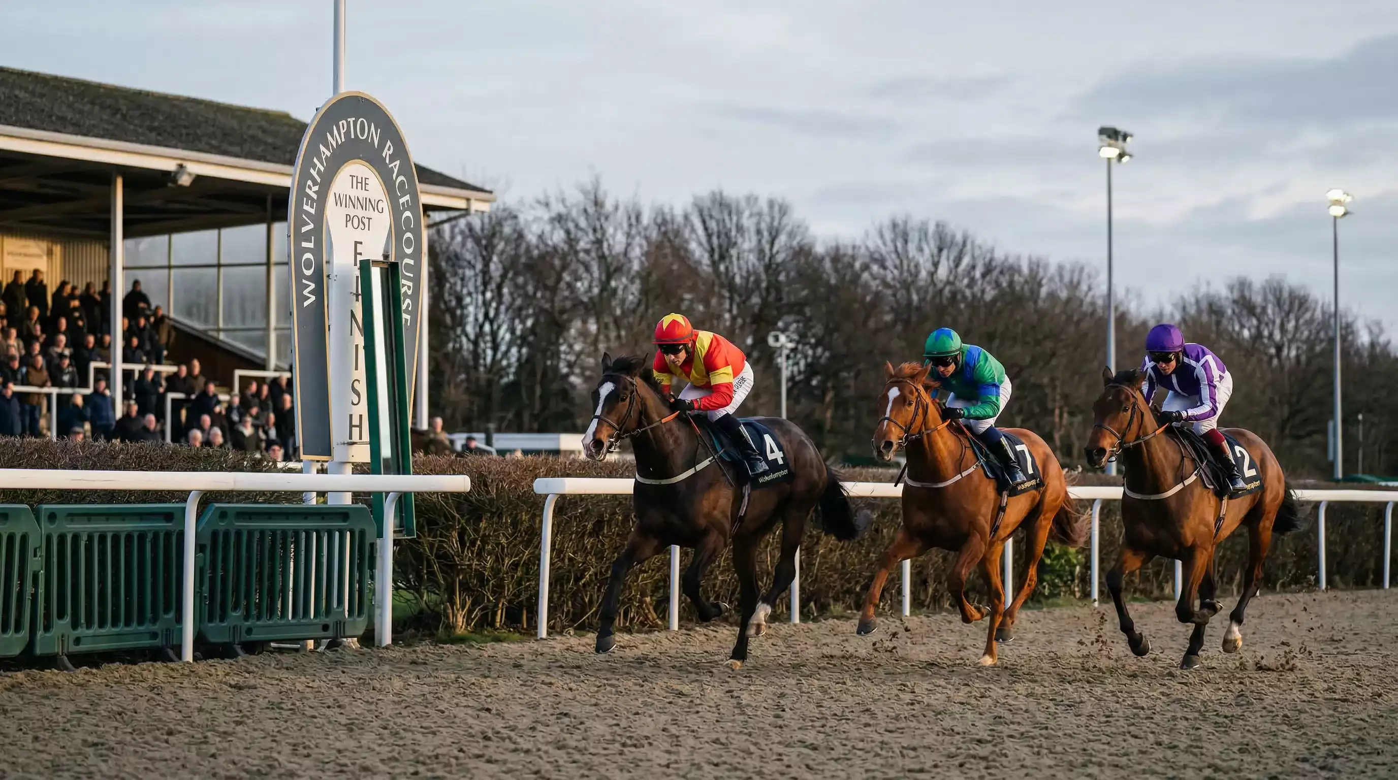 Winter afternoon flat racing at Southwell on the all-weather track with low sunlight across the Tapeta surface